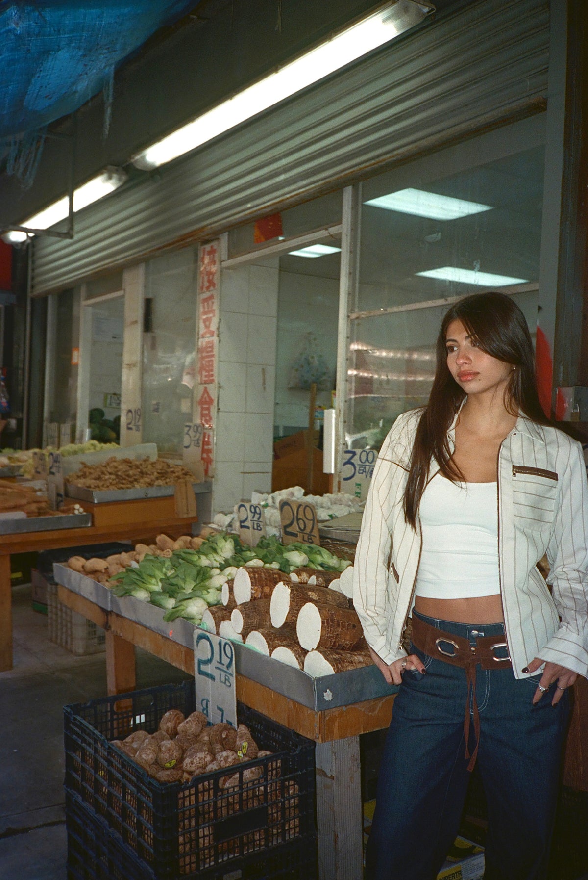 Model in the Louie Shirt in Cream standing beside a fruit and vegetable stand