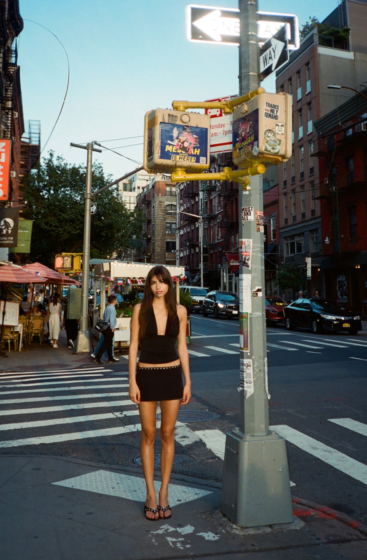 Model in the Phia Skort in Onyx, a black low-rise skort, with a black halter top on a street corner