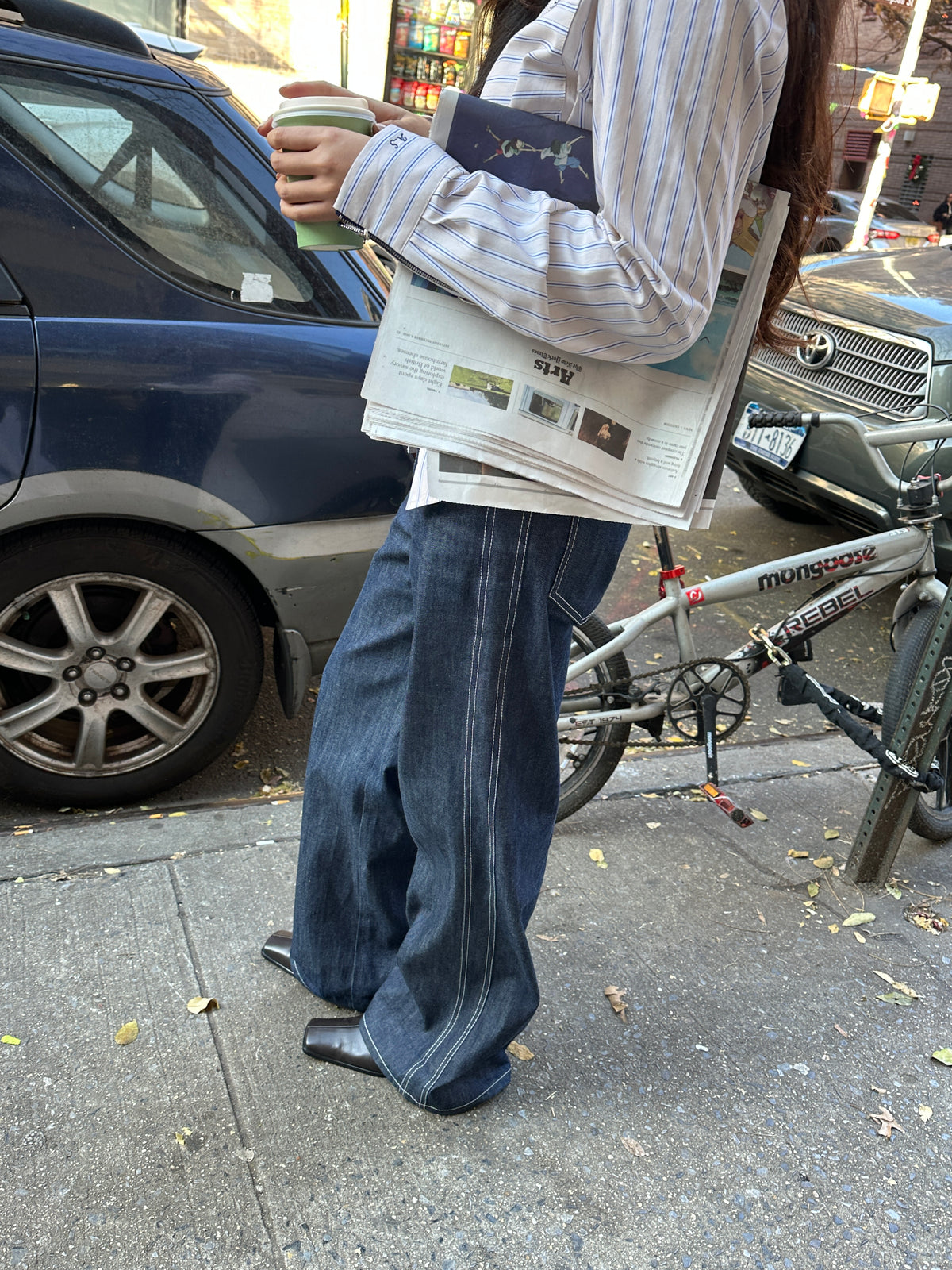 Close-up of the Lottie Jean in Indigo's wide leg and contrast stitching on a sidewalk