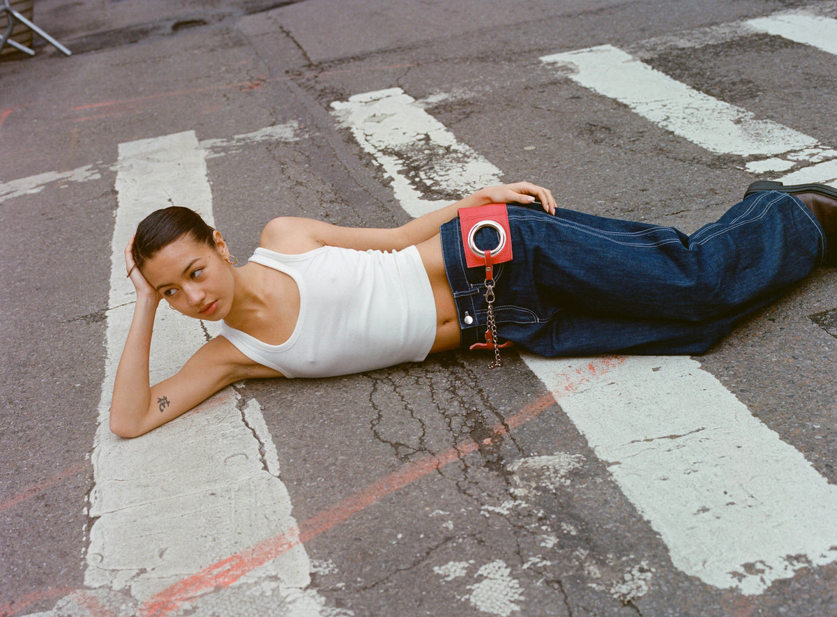 Model in the Lottie Jean in Indigo lying across a crosswalk