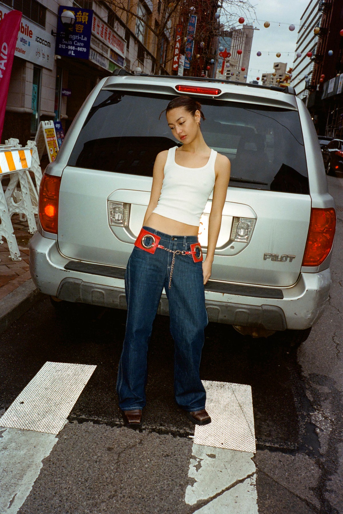 Front view of the Lottie Jean in Indigo with a white tank, standing in front of a car